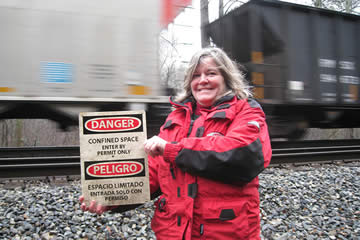 My friend Amy holding a sign as train speeds by in the backgroung